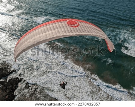 Beauty of paragliding flying,paragliders flying over scenic coast of Morocco,soaring on wind on beautiful cliffs and sand dunes,aerial panorama landscape view,outdoor extreme aerial sports