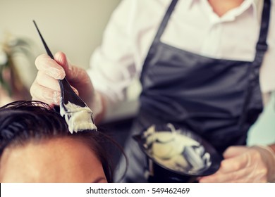 Beauty And People Concept - Close Up Of Stylist With Hair Dye And Brush Coloring Hair At Salon