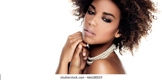 Beauty photo of young elegant african american woman with afro. Girl wearing pearls. Glamour makeup. Studio shot.