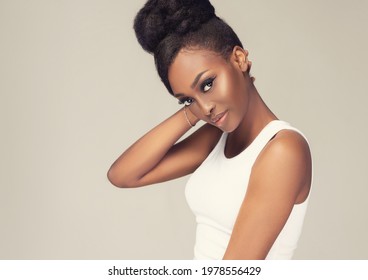 Beauty Portrait Of African American Black  Woman With Clean Healthy Skin . Life Style And Cosmetic. Smiling Beautiful Afro Girl.Curly Afro Hair  Tied In A Hairstyle Bun