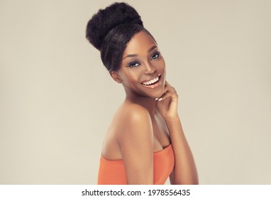 Beauty portrait of african american black  woman with clean healthy skin . Life style and cosmetic. Smiling beautiful afro girl.Curly afro hair  tied in a hairstyle bun