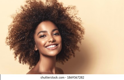 Beauty Portrait Of African American Girl With Clean Healthy Skin On Beige Background. Smiling Dreamy Beautiful Black Woman.Curly Hair In Afro Style