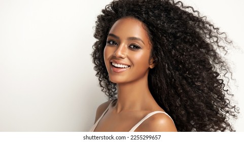 Beauty portrait of african american girl with clean healthy skin on beige background. Smiling dreamy beautiful black woman.Curly  hair in afro style  - Shutterstock ID 2255299657