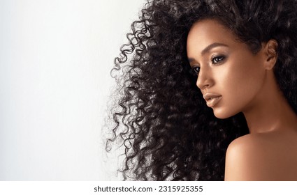 Beauty portrait of african american girl with clean healthy skin on beige background. Smiling dreamy beautiful black woman.Curly  hair in afro style  - Shutterstock ID 2315925355