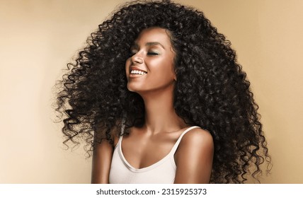 Beauty portrait of african american girl with clean healthy skin on beige background. Smiling dreamy beautiful black woman.Curly  hair in afro style  - Shutterstock ID 2315925373