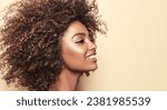 Beauty portrait of african american woman with clean healthy skin on beige background. Smiling dreamy beautiful afro haitstyle  girl.Curly black hair .