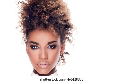 Beauty portrait of african american woman with afro hairstyle. Girl wearing white bow tie. Looking at camera. Studio shot. White background.