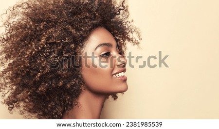 Beauty portrait of african american woman with clean healthy skin on beige background. Smiling dreamy beautiful afro haitstyle  girl.Curly black hair .