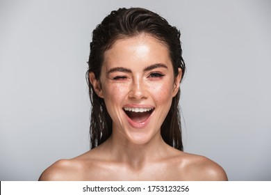 Beauty Portrait Of An Attractive Smiling Sensual Young Woman With Wet Brunette Long Hair Standing Isolated Over Gray Background, Winking