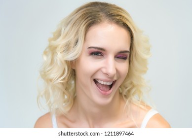 Beauty portrait of a beautiful blonde girl on a white background with perfect makeup. Beauty style model is right in front of the camera and looks happy. - Shutterstock ID 1211897464