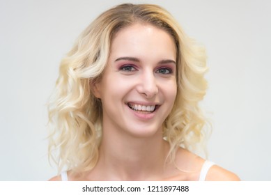 Beauty portrait of a beautiful blonde girl on a white background with perfect makeup. Beauty style model is right in front of the camera and looks happy. - Shutterstock ID 1211897488