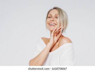 Beauty portrait of blonde smiling laughing woman 35 year plus clean fresh face with close eyes isolated on the white background