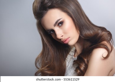 Beauty portrait of a brown-haired sexy girl with elegant hair isolated on gray background. - Shutterstock ID 553611529