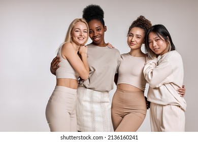 beauty portrait of diverse women, caucasian, asian and african american ladies with different skintone posing at camera, hugging each other, dressed casually in beige tone clothes. isolated - Shutterstock ID 2136160241