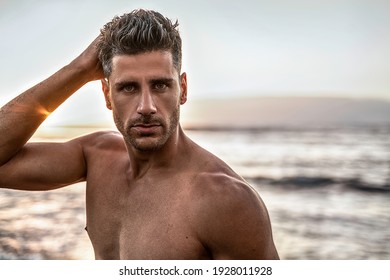 Beauty Portrait Of Handsome, Sexy Italian Man With Beard And Stunning Eyes Posing On The Beach, Sunset Summer Time. Tanned Skin. 