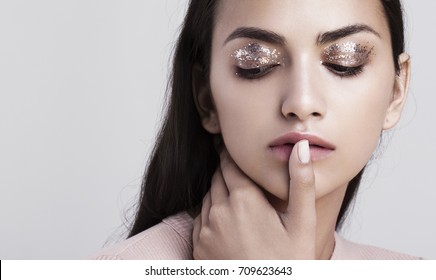 A Beauty Portrait Of An Indian Model With Glitter Makeup Touching Her Lips.