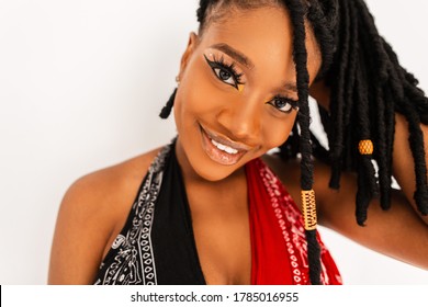 Beauty portrait pretty charming black woman with sweet smile and sexy lips with trendy dreadlocks in fashion bandana top on white background indoors. Happy smiling afro girl with clean healthy skin.