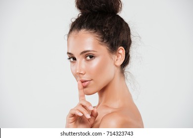 Beauty Portrait Of A Pretty Smiling Woman With Healthy Skin Showing Silence Gesture With Finger Over Her Lips Isolated Over White Background