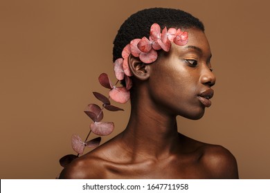 Beauty Portrait Of Pretty Young Half-naked African Woman Holding Exotic Flower Isolated Over Brown Background