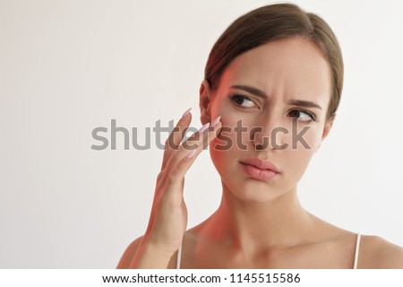 beauty portrait of sad woman touching her skin on white background 