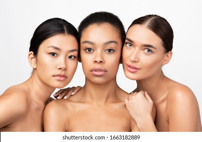 Beauty. Portrait Of Three Mixed Girls Looking At Camera Posing Naked Over White Background. Studio Shot