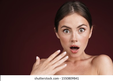 Beauty portrait of a topless attractive shocked woman isolated over background, looking at camera