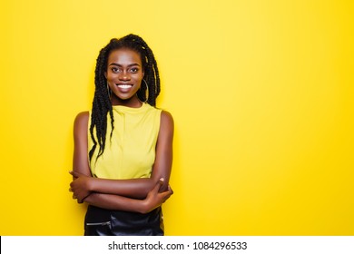 Beauty portrait of young african american girl posing on yellow background, looking at camera.
