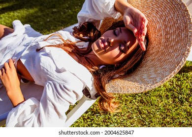 Beauty Portrait Of A Young African - American Woman In The Sun At Sunset. Fashion Black Girl In A Straw Hat While Relaxing By The Pool.  