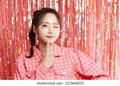Beauty portrait of a young Asian woman with sticker makeup on glittery background