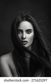 Beauty Portrait Of A Young Beautiful Brunette Girl With Long Black Straight Flying Hair. Magnificent Hair. Black And White