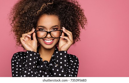 Beauty portrait of a young black healthy woman holding glasses and looking at camera  - Shutterstock ID 735395683