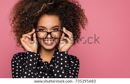 Beauty portrait of a young black healthy woman holding glasses and looking at camera 