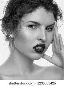 beauty portrait of young fashionable woman showing gorgeous trendy makeup posing with bare shoulders on white studio background black and white