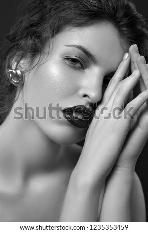 beauty portrait of young female  posing with bare shoulders on dark studio background black and white