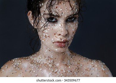 Beauty Portrait Of A Young Girl With A Clean Wet Skin In Shells And Wet Hair On A Dark Blue Background