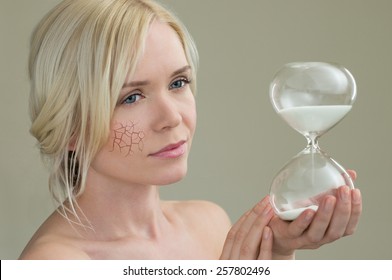 Beauty Portrait Of Young Woman Holding Hour Glass Sand Timer, Aging Process Concept
