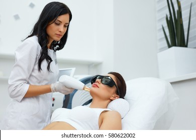 Beauty Procedure. Closeup Of Beautician Using Laser Therapy For Facial Skin Rejuvenation. Beautiful Healthy Woman Face Getting Skin Resurfacing In Spa Salon. Body Treatment. High Resolution