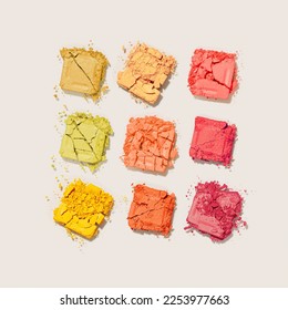 Beauty product eyeshadows for makeup as minimal square pattern beige background  flat lay yellow red colors swatch eyeshadows  cosmetic textures  professional color pallete  top view still life