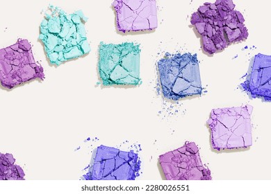 Beauty product eyeshadows for makeup as minimal pattern beige fon  copy space  flatly blue teal violet colors swatch eyeshadows  cosmetic textures  professional color pallete  top view still life