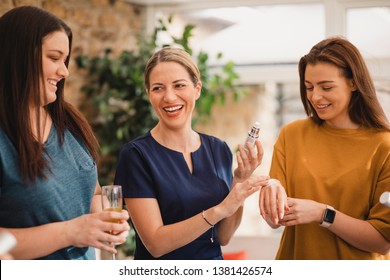 A Beauty Product Sales Representative Showing Customers Products. She Is Letting An Unrecognisable Person Sample A Beauty Product On The Back Of Her Hand.