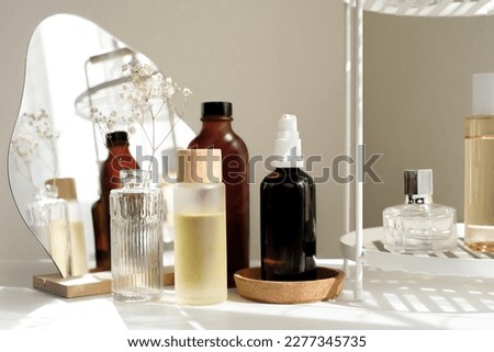 The beauty product and skincare set on the bath shelf with luxury flowers and a mirror for the spa concept.  