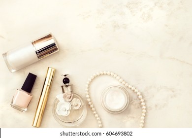 Beauty products, decorative cosmetics top view on white marble background. Flat lay for fashion blogger. Copy space