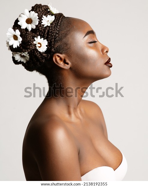 Beauty\
Profile of African American Woman with White Chamomile Flowers in\
Black Hair Braids. Fashion Portrait of Dark Skin Model over White.\
Wedding Make up and Bride Cornrows\
Hairstyle