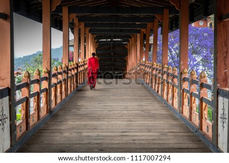 The beauty of Punakha Dzong is incomplete without its monks, drapped in red robe. 商業照片 © 