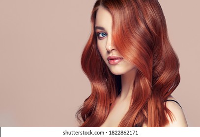 Beauty redhead girl with long  and   shiny wavy red hair .  Beautiful   woman model with curly hairstyle .
				