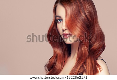 Beauty redhead girl with long  and   shiny wavy red hair .  Beautiful   woman model with curly hairstyle .

