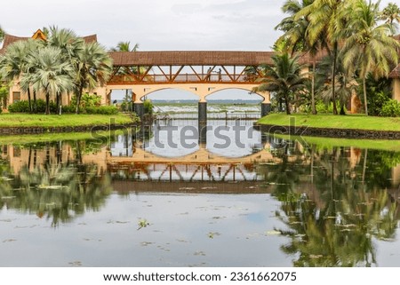 Beauty of the reflections on water along with the reflection of clouds at Zuri Resorts, Kumarakom , Kerala. The picture depicts the beauty of symmetry's of nature , buildings , bridge and structure