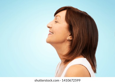 Beauty, Rhinoplasty And Old People Concept - Profile Of Smiling Senior Woman Over Blue Background