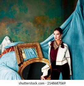 Beauty Rich Brunette Woman In Luxury Interior Near Empty Frames, Wearing Fashion Clothes, Lifestyle People Concept