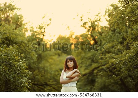 Similar – Junge Frau sitzt auf einer Bank in einem Park in ruhiger Pose.